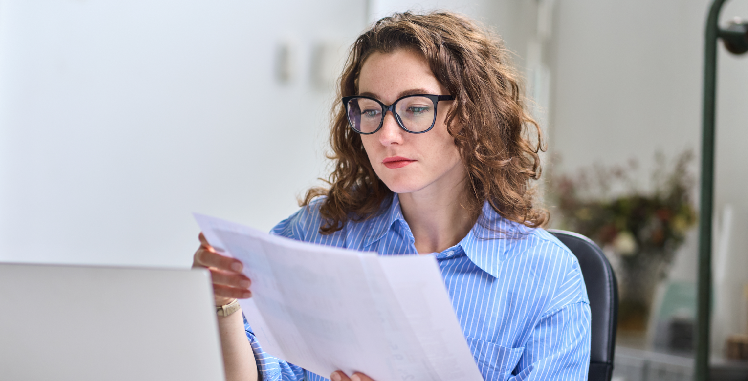 Eine Frau schaut sich ihre Zahnarztrechnung an.