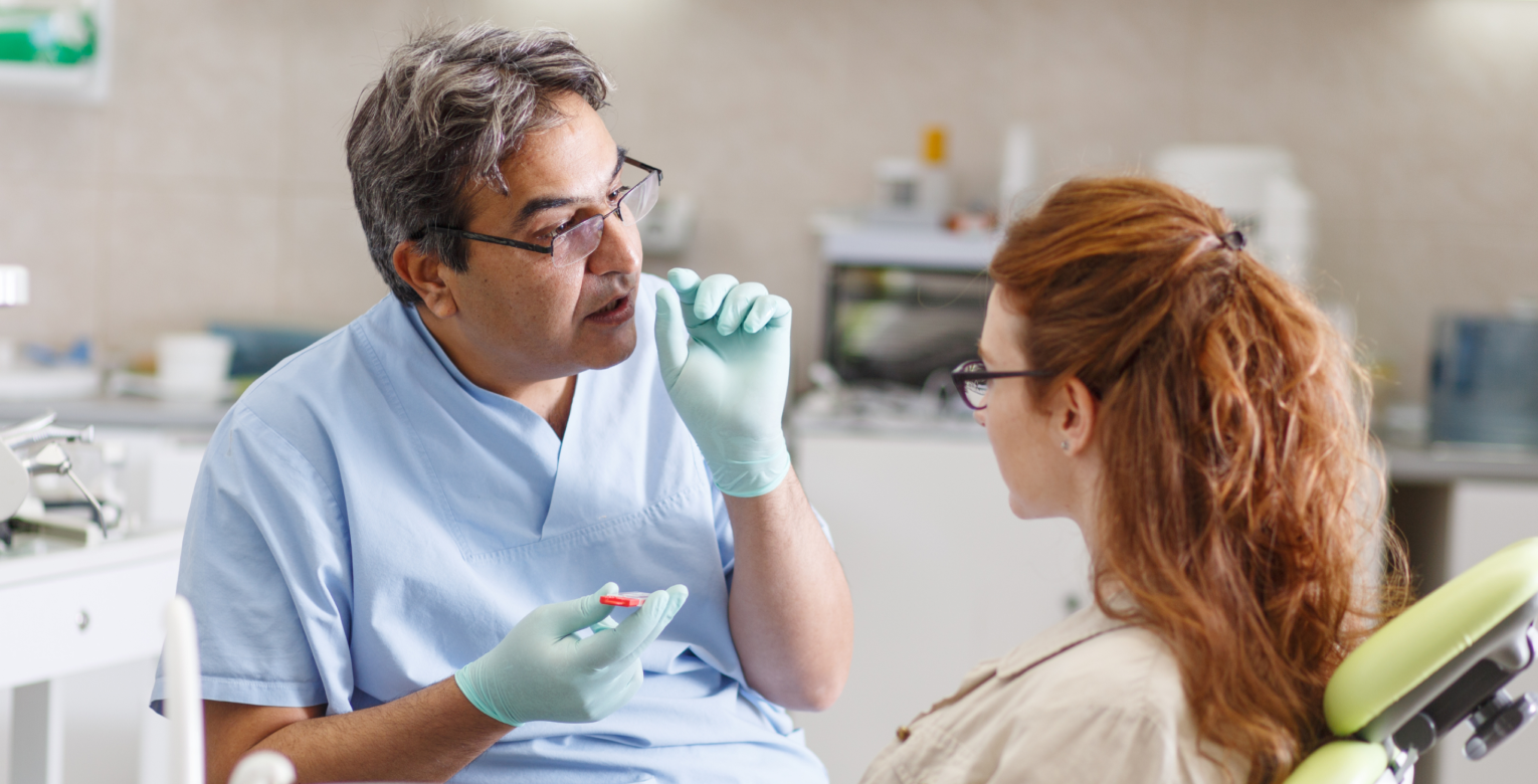 Eine Studentin wird von einem Zahnarzt behandelt.
